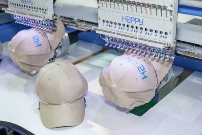 The emboirdery machines putting logos stiched into hats